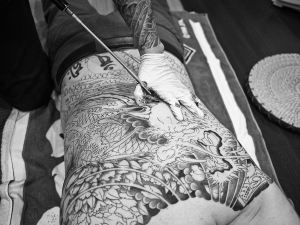 Esecuzione di un tatuaggio sulla schiena tramite la tecnica thailandese